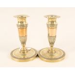 A pair of early 19th Century French brass and copper candlesticks with circles of fluted and chased