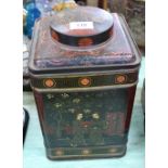 An oriental decorated metal tea canister