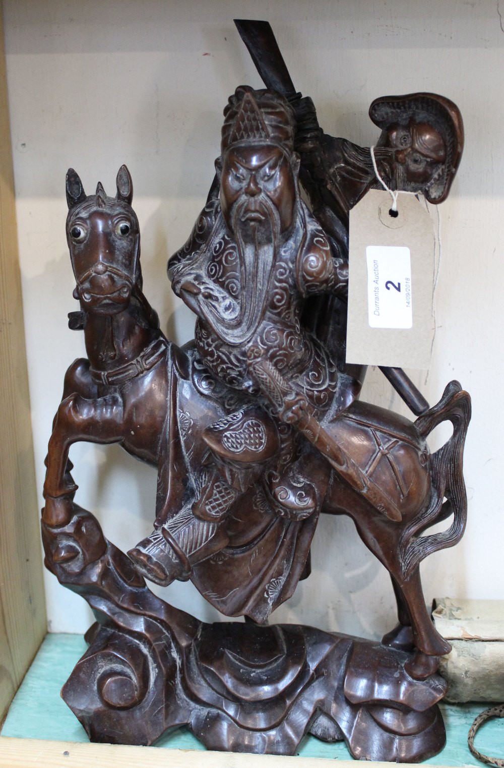 A Chinese carved hardwood figure of a mounted warrior and attendant,