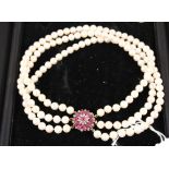 A three strand pearl choker with large 9ct gold clasp set with rubies and diamonds