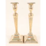 A pair of 18th Century Adam style brass candlesticks with tapering fluted columns and beaded square