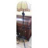 A black wrought iron standard lamp with rattan shade