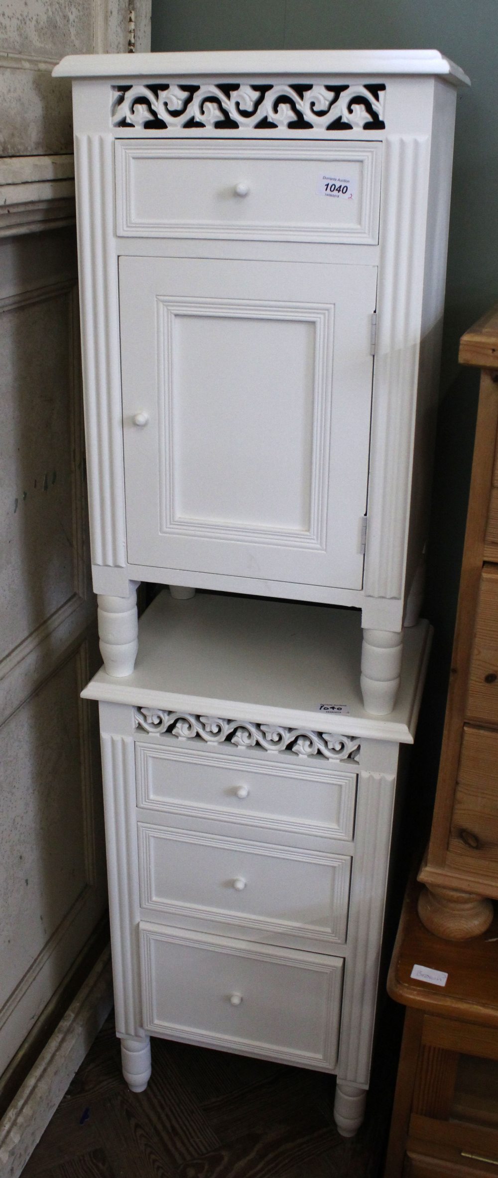 A pair of modern white painted bedside cabinets with fretwork decoration