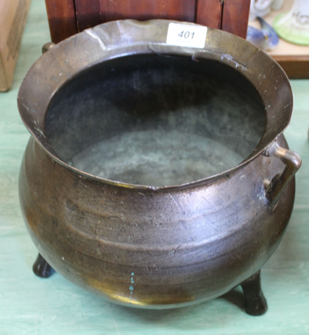 A 17th Century bronze cauldron with bellied body, flared rim,