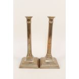 A pair of 18th Century seamed brass candlesticks with fluted cylindrical stems and engraved square