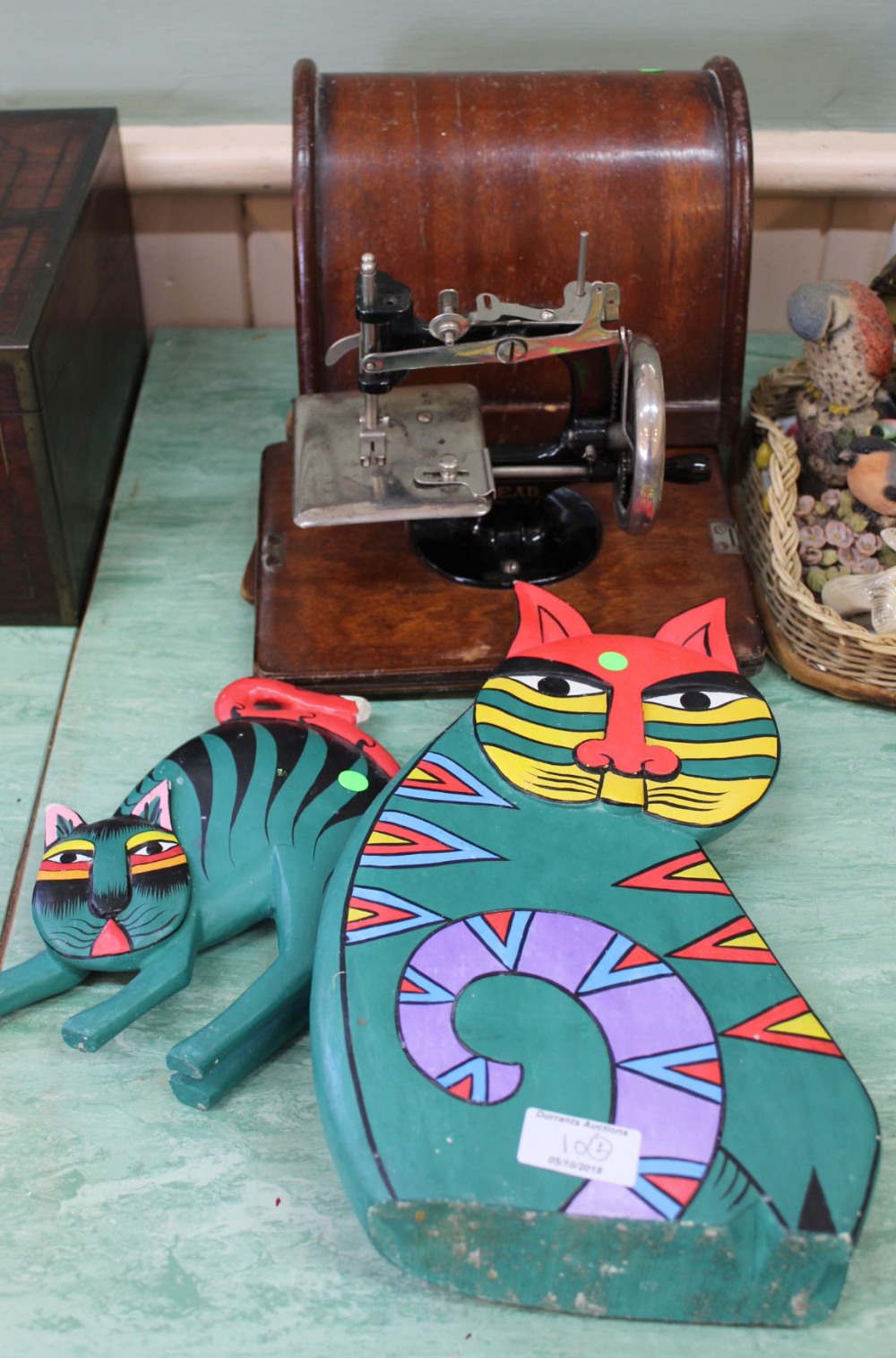 A 'lead' childs sewing machine plus two painted wooden cats