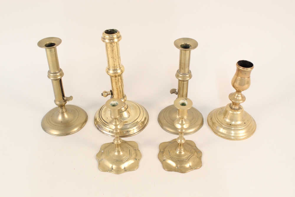 Four 18th Century brass candlesticks to include a pair with side ejectors plus a pair of brass