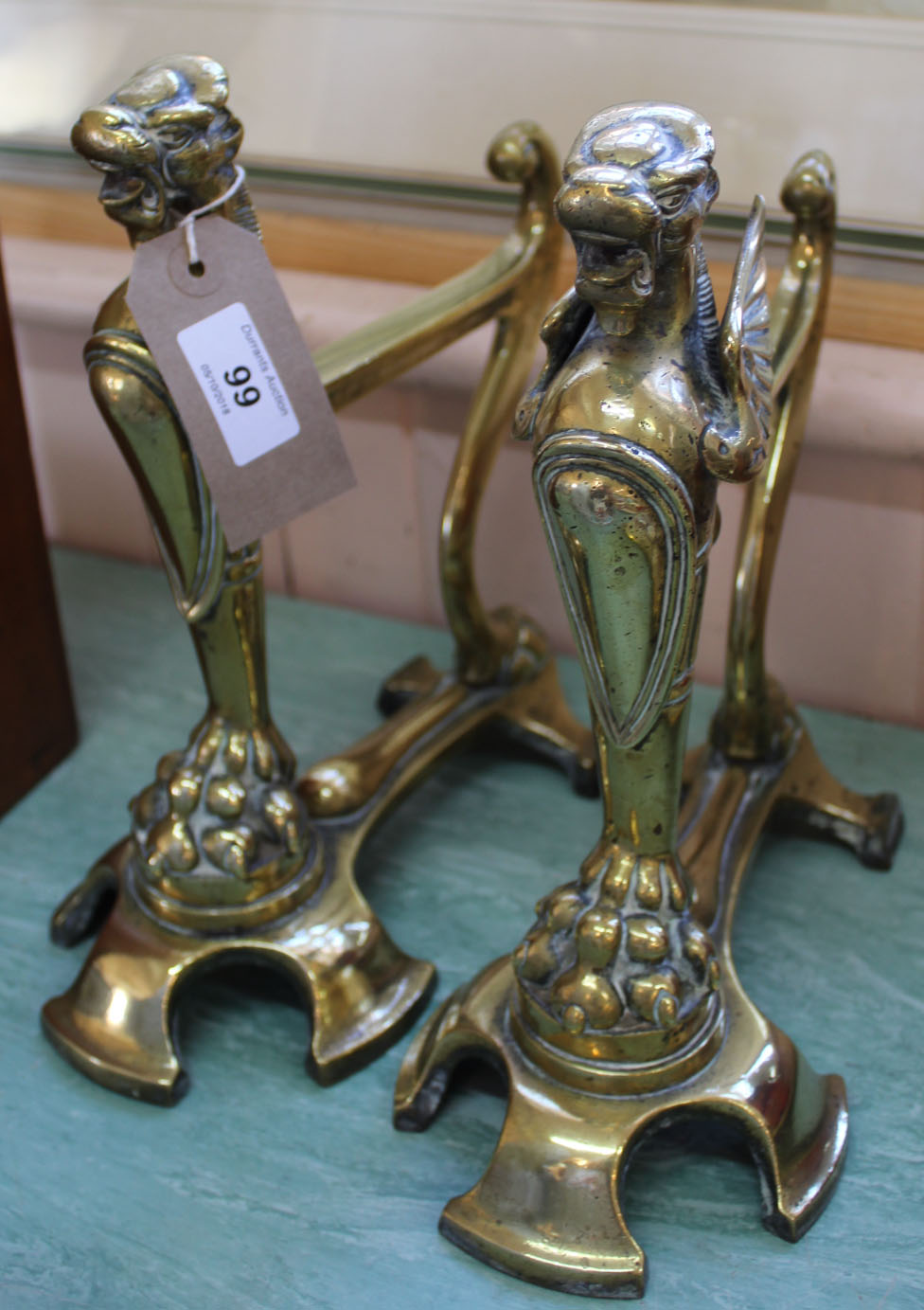 A good quality pair of 19th Century brass Griffin fire dogs,