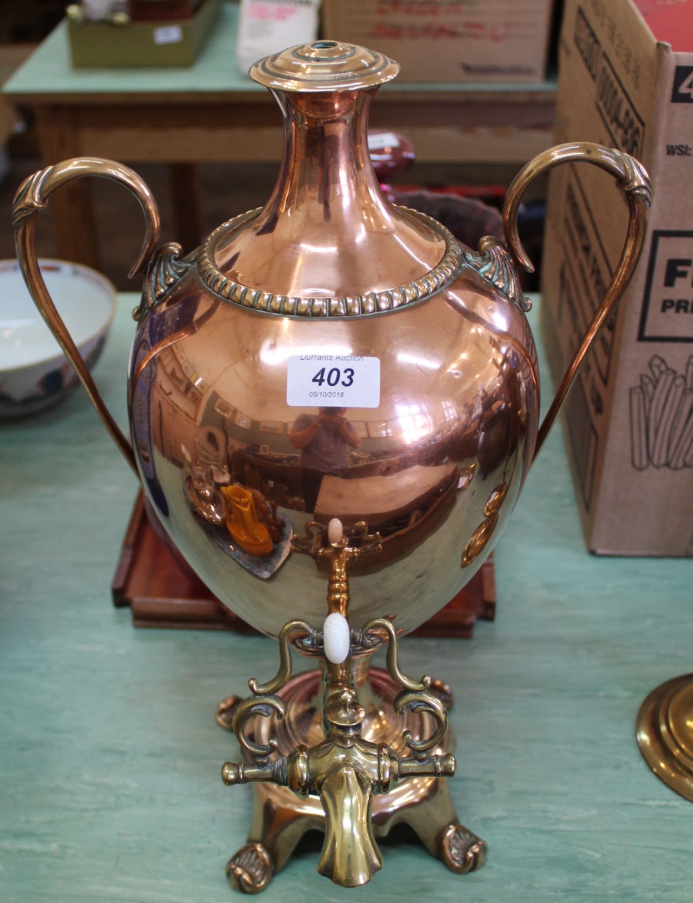 A 19th Century copper samovar of ovoid pedestal form with waisted lid, twin swan neck handles,