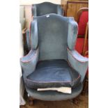 A pair of wingback blue upholstered armchairs on mahogany ball and claw feet