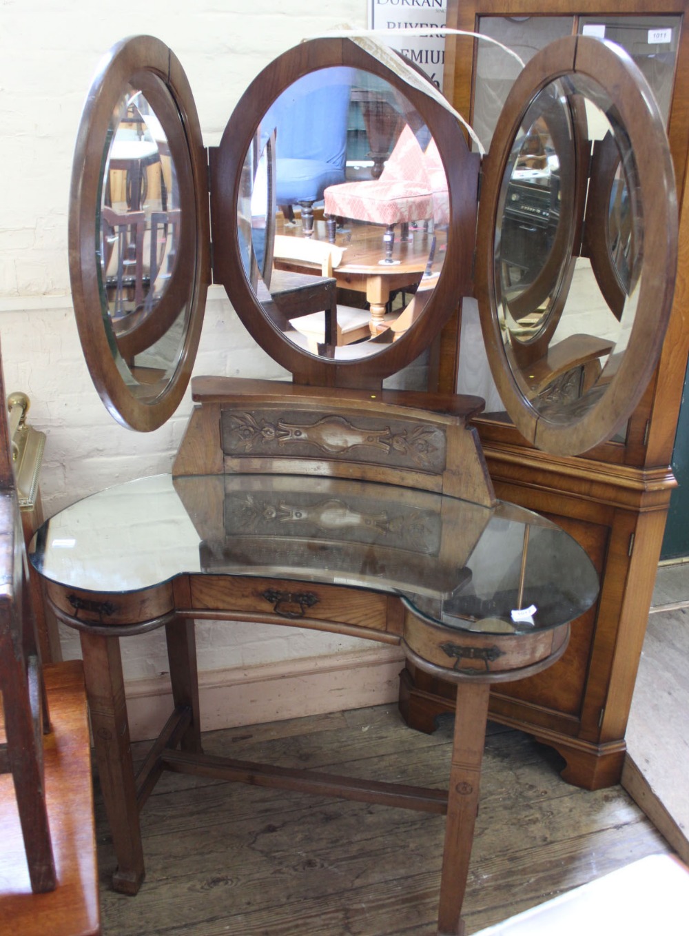 An unusual Arts and Crafts kidney shaped dressing table with triple oval mirror