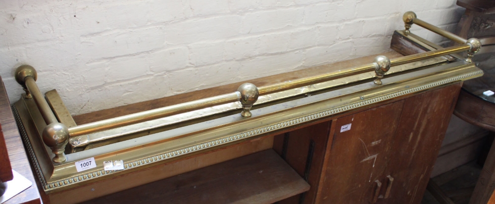 A brass fender with rail top and one other