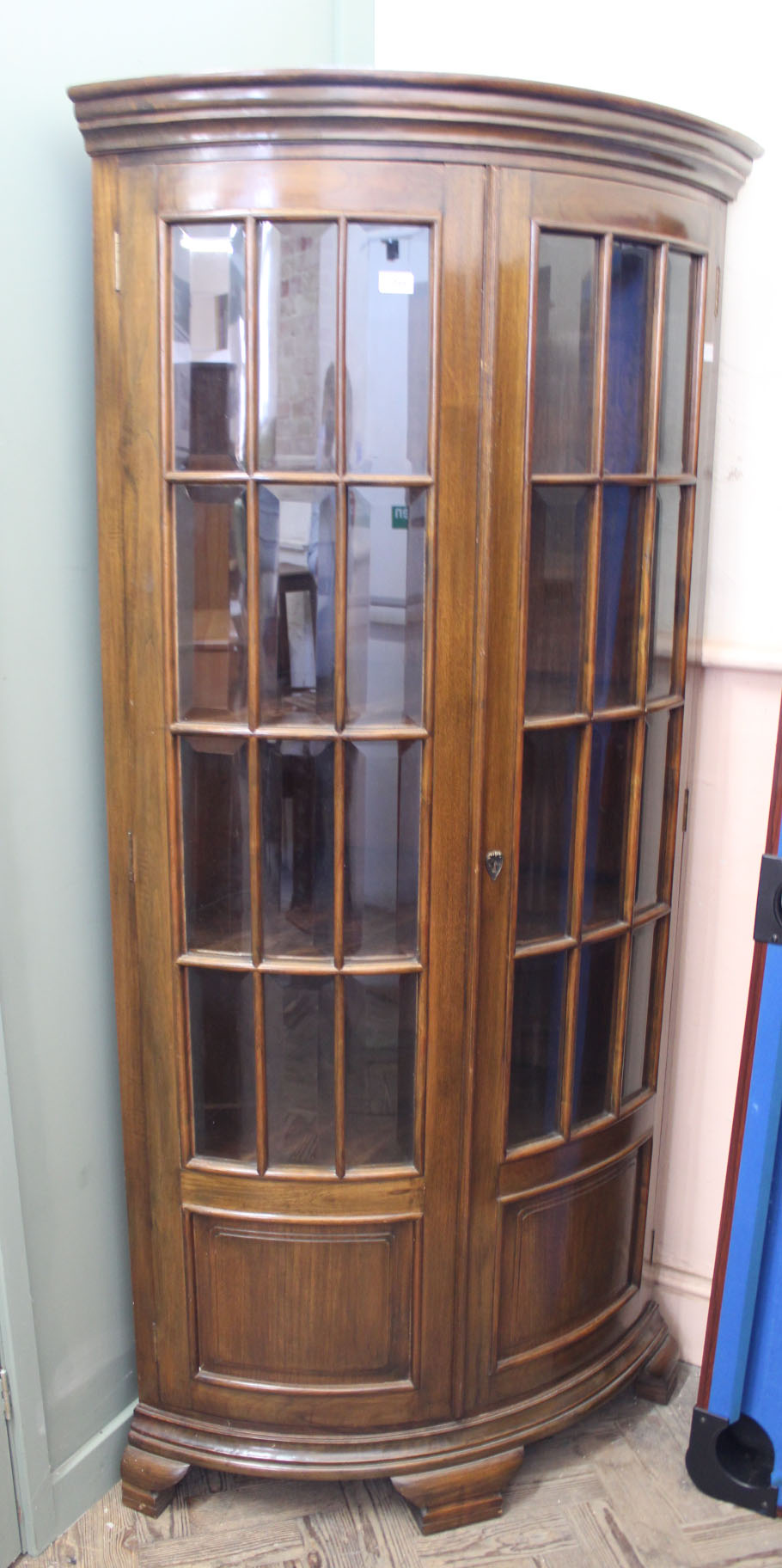 A reproduction mahogany bow front corner cupboard with two doors