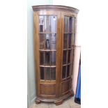 A reproduction mahogany bow front corner cupboard with two doors