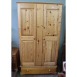 A modern pine two door wardrobe with single drawer
