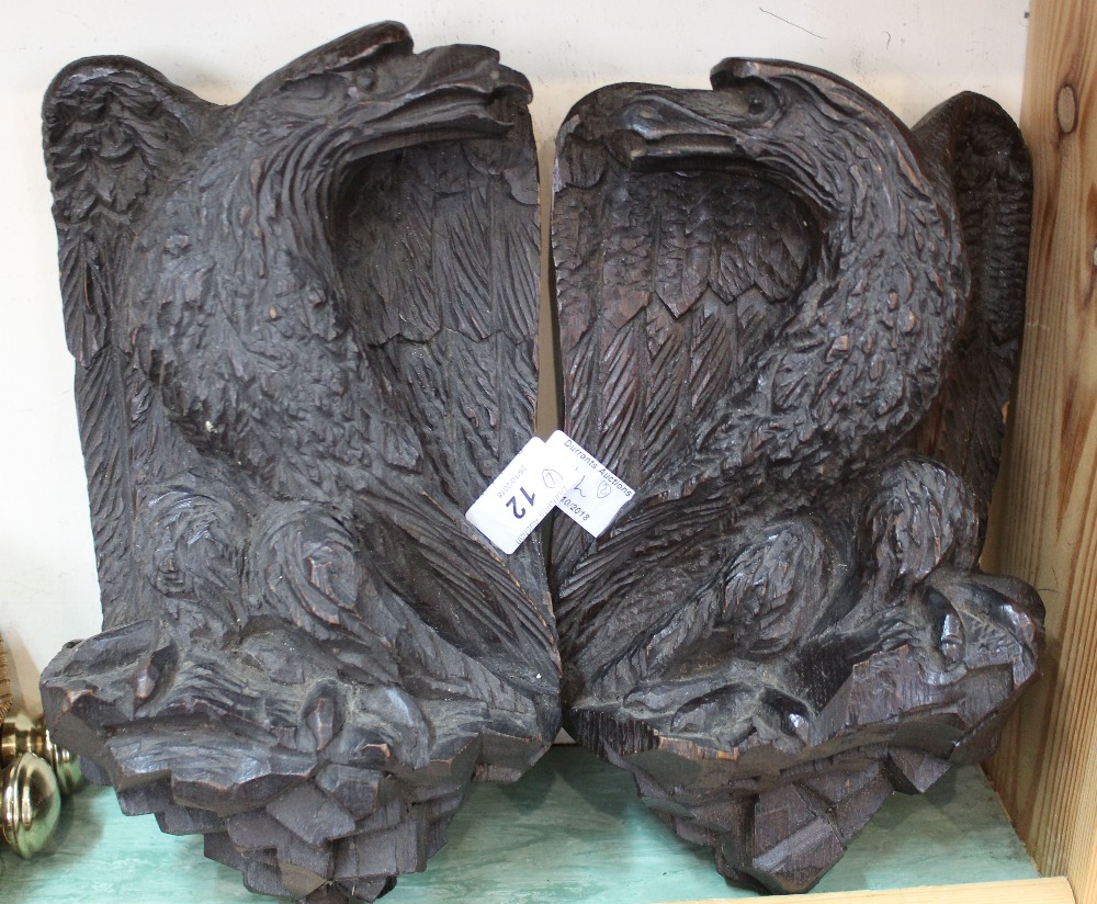 A pair of carved wooden eagle wall plaques,