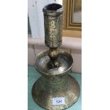 A large heavy antique Islamic brass candlestick with wide bell shaped base,