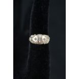 A 9ct gold ring with scrollwork detail set with three small diamonds,