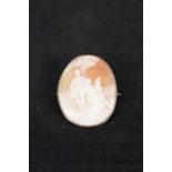 A yellow metal framed cameo brooch decorated with family scene