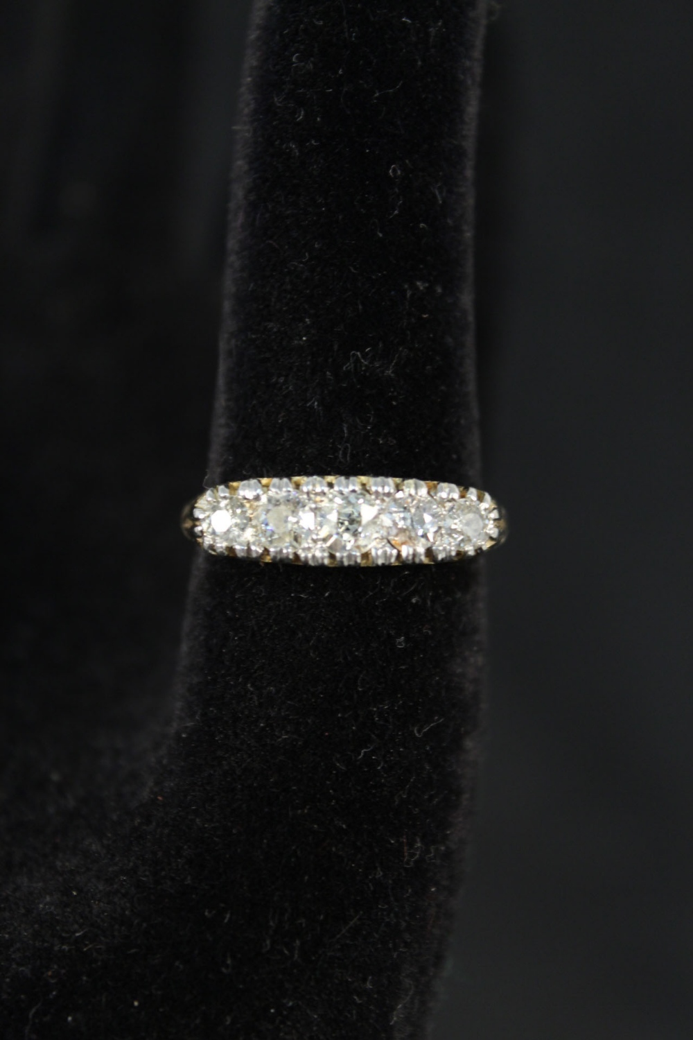An 18ct platinum set five stone diamond ring with intricate scroll setting,