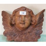 A carved mahogany winged cherub