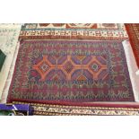 A Persian red ground rug with central medallions,