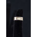 A 15ct gold band ring with sectional design to outer band,