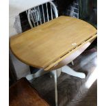 A modern pine and cream painted drop leaf pedestal table and a chair