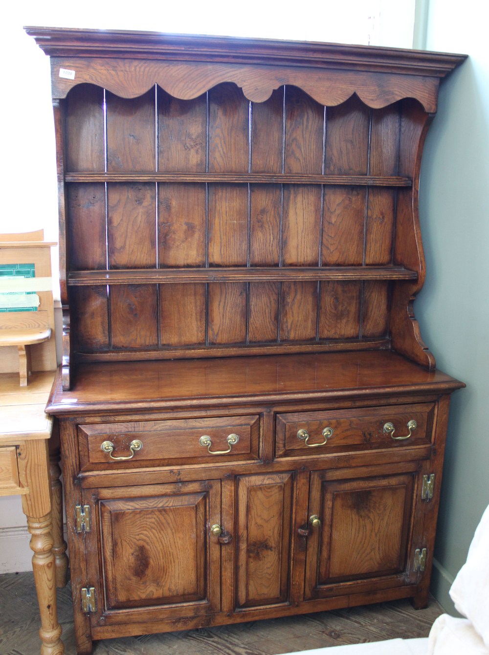 A shelf back oak kitchen dresser with brass hardwear