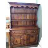 A shelf back oak kitchen dresser with brass hardwear