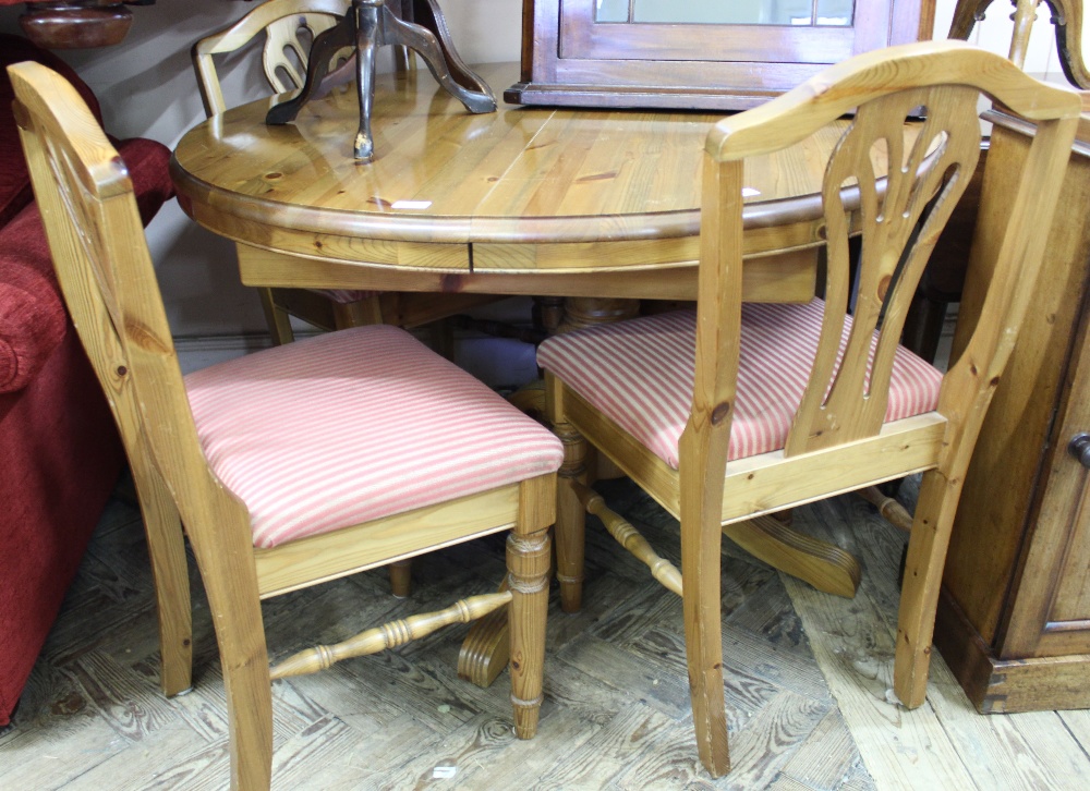 A modern pine round dining table and four chairs