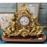 A 19th Century French ormolu mantel clock flanked by seated cherubs with rococo and floral