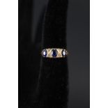 An 18ct gold ring set with three blue stones interspersed with diamonds (one stone is damaged),