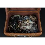 A basket weave case with large quantity of costume jewellery including rings, brooches,