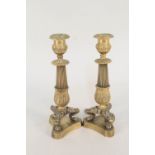 A pair of 19th Century brass three footed candlesticks