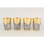 A set of four 19th Century Elkington & Co gilded metal goblets with applied white metal cherub,