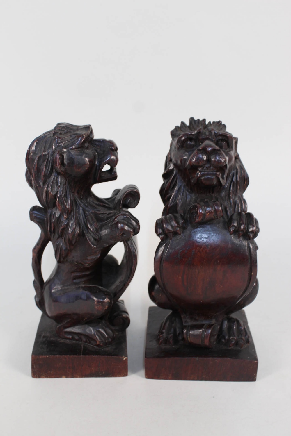 A pair of 19th Century carved mahogany heraldic lions,