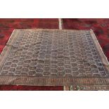 A Persian rug with repeating central design,