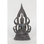 A Nepalese bronze of a seated deity with calligraphy to base,