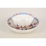 A Lowestoft tea bowl and saucer with dolls house pattern,