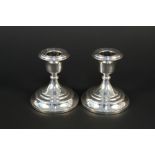 A pair of filled silver squat candlesticks,