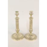 A pair of early 19th Century French seamed brass candlesticks with engine decoration,