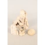 A Chinese bone figure of a seated man with deer,