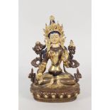 A Tibetan gilt bronze of a seated female deity with painted decoration,