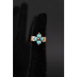 A gold band ring set with four turquoise stones and small ruby to centre,