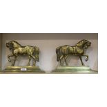 A pair of late Victorian brass door stops each in the form of a trotting horse on a stepped plinth