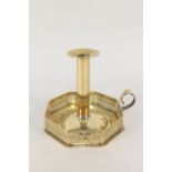 An Arts and Crafts chamberstick having octagonal shaped base with pierced gallery,