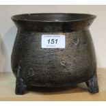 A small 17th Century bronze cauldron with flared rim and three moulded legs,