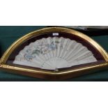 A glazed fan case containing an ivory and floral silk fan