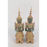 A pair of Thai gilt and patinated bronze kneeling deities at prayer,
